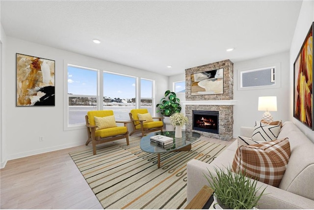 1517 Creekwood Dr, New Richmond, WI 54017 - living room featuring light wood-style floors, a stone fireplace, baseboards, a water view, and recessed lighting