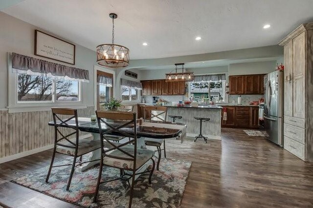 8283 345th St, Stanley, WI 54768 - dining room featuring dark wood-style flooring, a wainscoted wall, recessed lighting, and an inviting chandelier