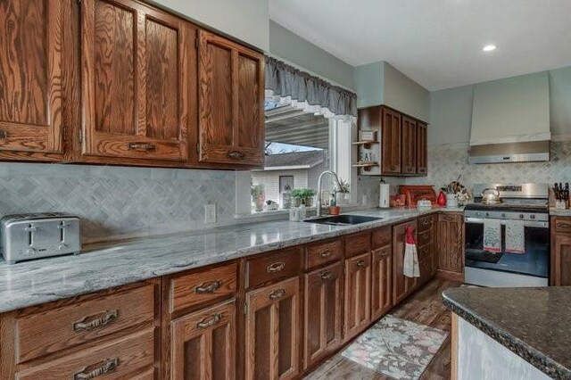 8283 345th St, Stanley, WI 54768 - kitchen featuring stainless steel range with electric stovetop, wall chimney exhaust hood, a sink, and light stone counters