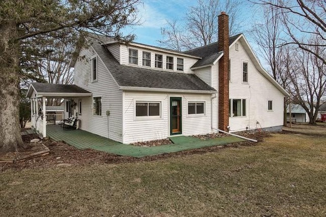8283 345th St, Stanley, WI 54768 - rear view of house with a shingled roof, a chimney, and a lawn