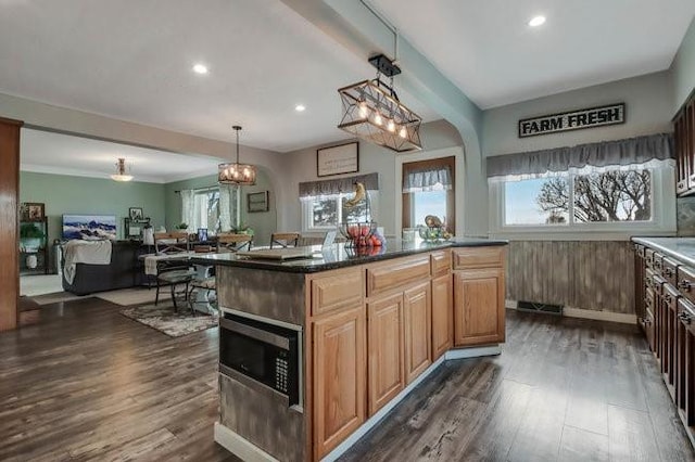 8283 345th St, Stanley, WI 54768 - kitchen featuring open floor plan, stainless steel microwave, dark countertops, and dark wood-style floors