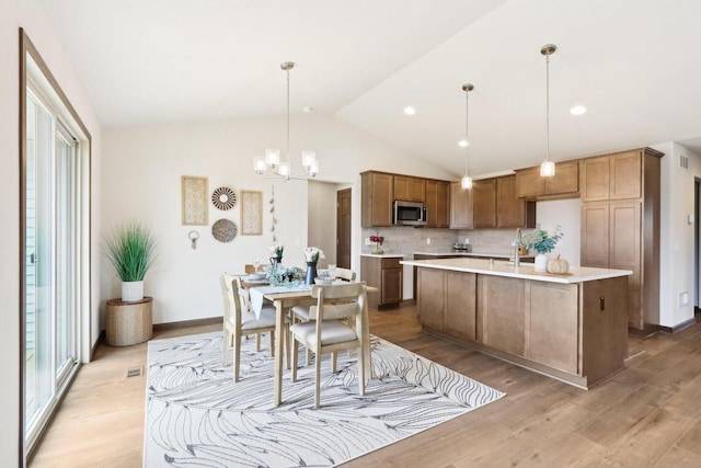 6101 Fox Run Ln, Mount Pleasant, WI 53406 - kitchen with stainless steel microwave, light countertops, vaulted ceiling, and a healthy amount of sunlight