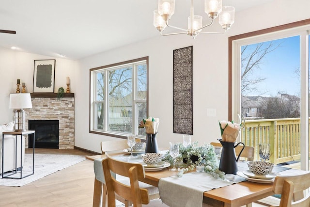 6101 Fox Run Ln, Mount Pleasant, WI 53406 - dining room with a stone fireplace, vaulted ceiling, light wood finished floors, baseboards, and a notable chandelier