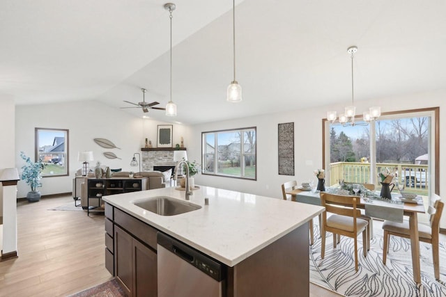 6101 Fox Run Ln, Mount Pleasant, WI 53406 - kitchen featuring light wood-type flooring, a stone fireplace, open floor plan, stainless steel dishwasher, and a sink