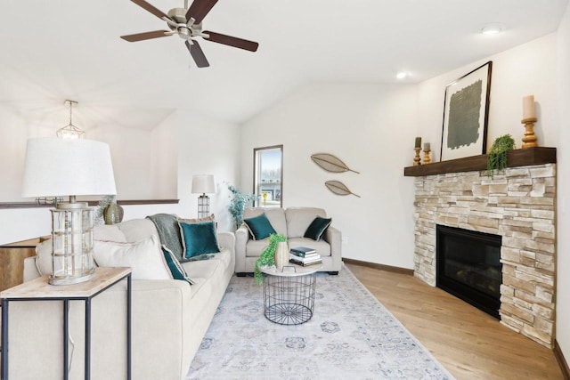 6101 Fox Run Ln, Mount Pleasant, WI 53406 - living area featuring baseboards, ceiling fan, a stone fireplace, vaulted ceiling, and light wood-style flooring