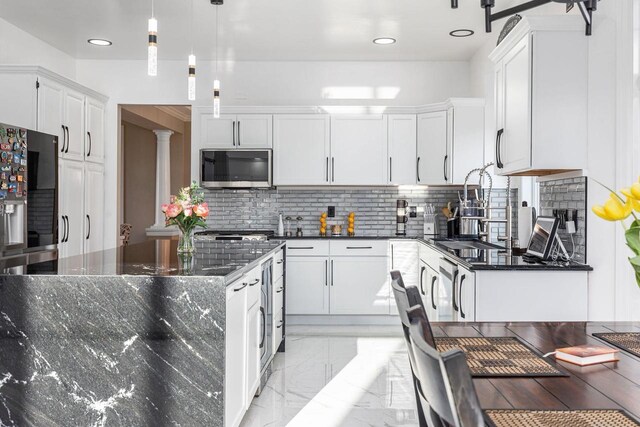 N4455 Dorothy Jane Ct, Kaukauna, WI 54130 - kitchen with decorative backsplash, stainless steel microwave, marble finish floor, and white cabinetry