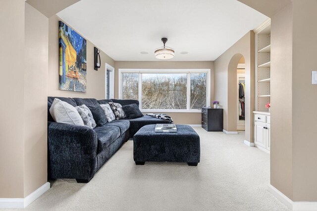 N4455 Dorothy Jane Ct, Kaukauna, WI 54130 - living room featuring baseboards, arched walkways, light colored carpet, and built in shelves