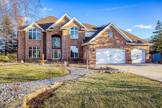 N4455 Dorothy Jane Ct, Kaukauna, WI 54130 - traditional home featuring a chimney, driveway, a front yard, brick siding, and a garage