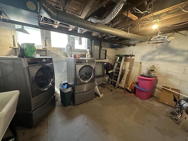 below grade area with washing machine and clothes dryer and a sink