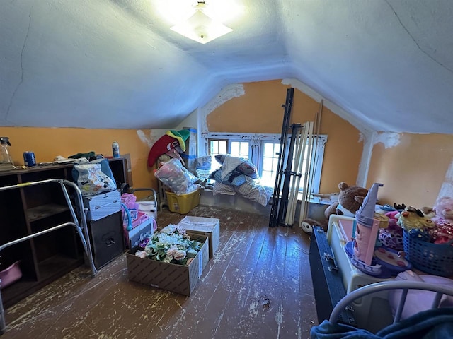 additional living space with hardwood / wood-style flooring and vaulted ceiling