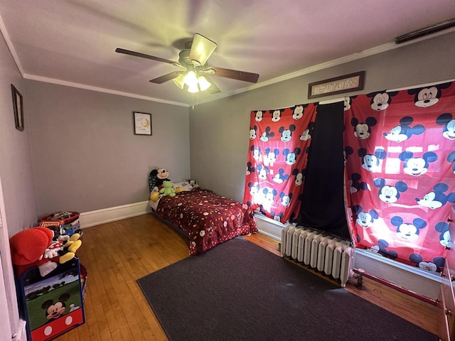 bedroom with crown molding, radiator heating unit, and hardwood / wood-style floors