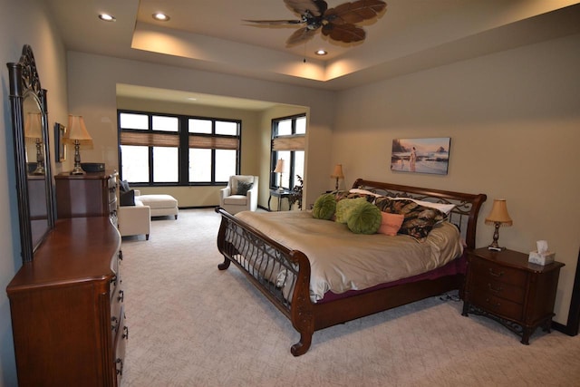 bedroom featuring a tray ceiling, light carpet, a ceiling fan, and recessed lighting