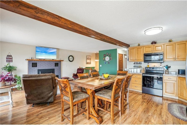 1794 W White Ash Dr, Balsam Lake, WI 54810 - dining space featuring beam ceiling, light wood-type flooring, a fireplace, and a textured ceiling