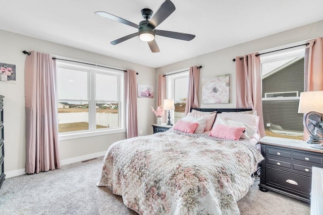 bedroom with light colored carpet, baseboards, multiple windows, and visible vents
