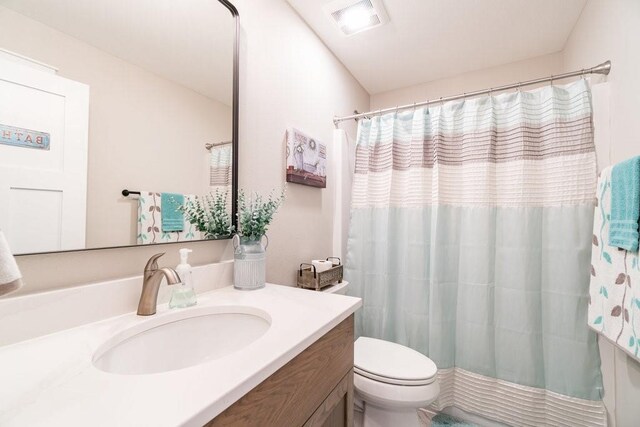 bathroom with toilet, vanity, a shower with shower curtain, and visible vents
