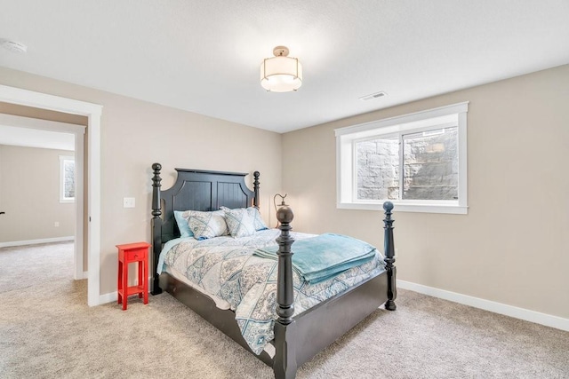 bedroom with baseboards, multiple windows, and light carpet