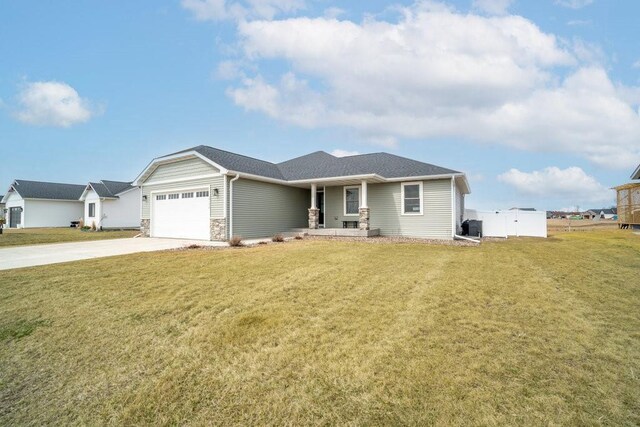 view of front facade featuring a garage, fence, stone siding, a front lawn, and driveway