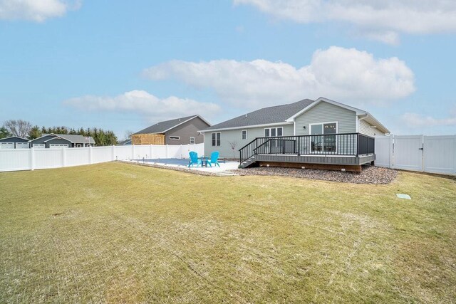 back of house with a yard, a fenced backyard, a patio, a wooden deck, and a gate
