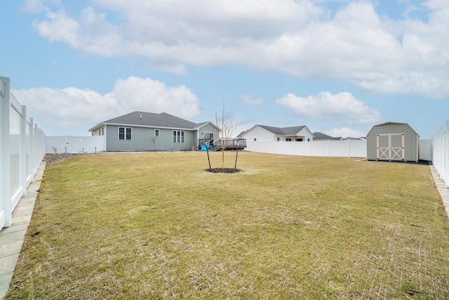 view of yard featuring a fenced backyard, an outbuilding, and a storage unit