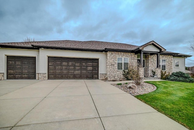 view of front of house with stone siding, an attached garage, a front yard, and concrete driveway