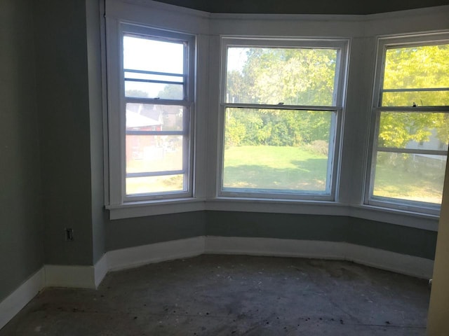 spare room featuring plenty of natural light and baseboards