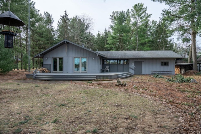 rear view of property featuring a wooden deck
