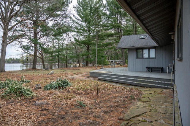 view of yard with a deck with water view