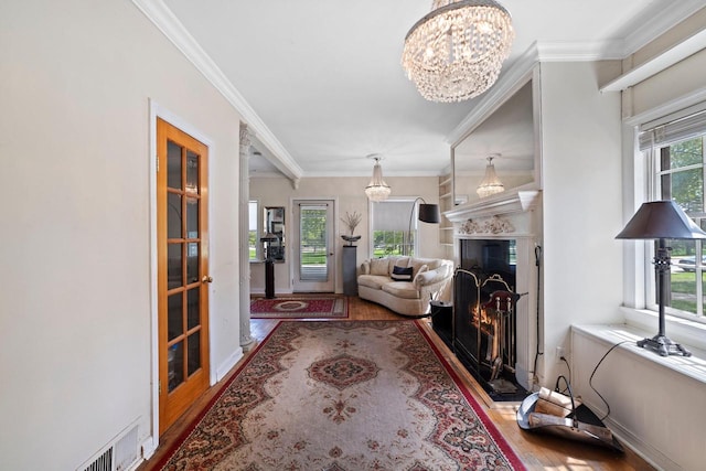 1941 S 124th St, New Berlin, WI 53151 - living area with an inviting chandelier, plenty of natural light, crown molding, visible vents, and wood finished floors