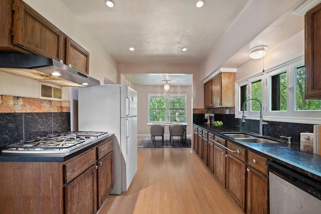 1941 S 124th St, New Berlin, WI 53151 - kitchen featuring backsplash, under cabinet range hood, light wood-style floors, appliances with stainless steel finishes, and a sink