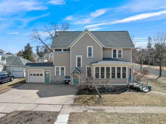 traditional home with driveway, a garage, and roof with shingles