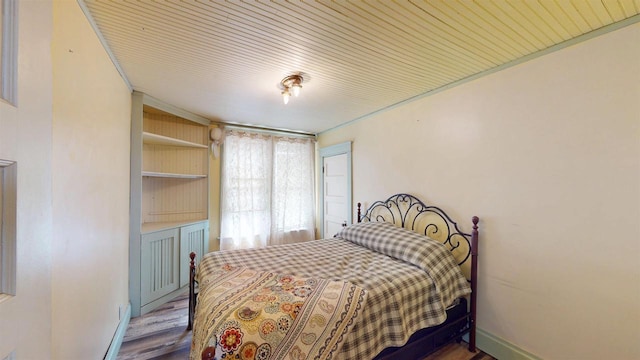 bedroom with baseboards and wood finished floors