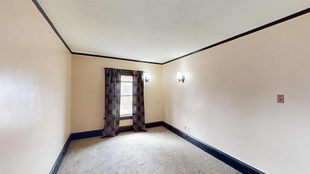 spare room with baseboards, ornamental molding, and carpet floors