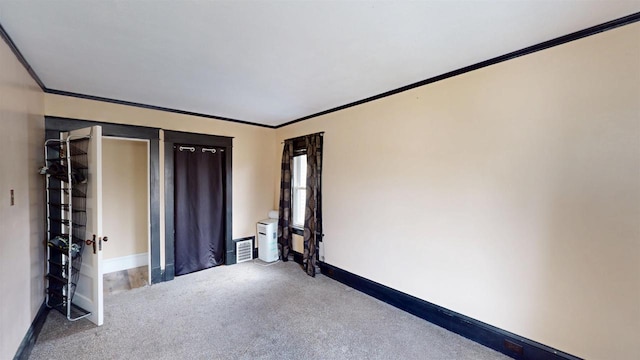 unfurnished bedroom featuring crown molding, visible vents, baseboards, and carpet