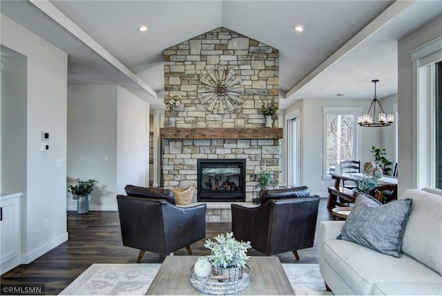 living area featuring baseboards, a chandelier, a fireplace, wood finished floors, and vaulted ceiling