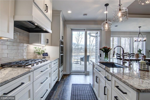 kitchen featuring white cabinets, a sink, dark wood-style flooring, premium range hood, and stainless steel appliances