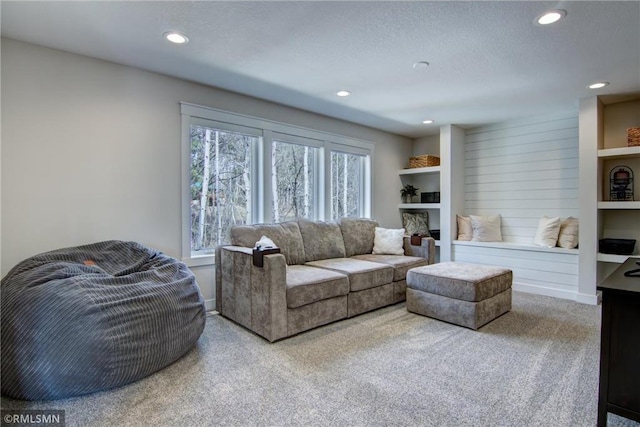 living area with recessed lighting, carpet, baseboards, and a textured ceiling
