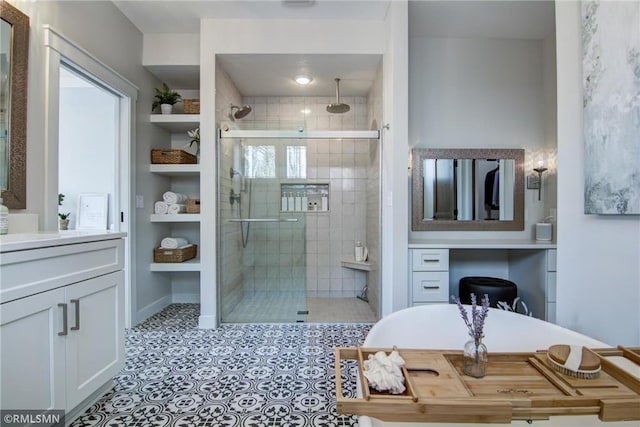 full bathroom featuring tiled shower, vanity, and baseboards