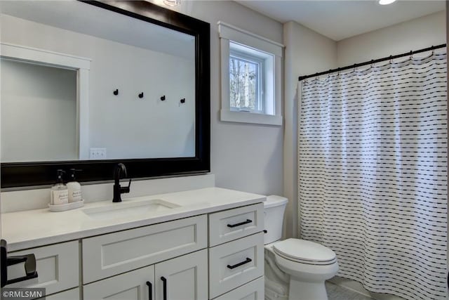 bathroom with curtained shower, vanity, and toilet