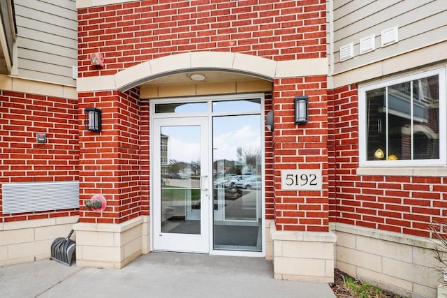 entrance to property featuring brick siding