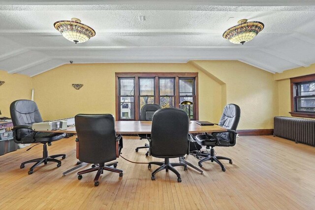 3316 W Wisconsin Ave, Milwaukee, WI 53208 - office featuring vaulted ceiling, a textured ceiling, radiator heating unit, a wealth of natural light, and wood-type flooring