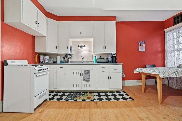 3316 W Wisconsin Ave, Milwaukee, WI 53208 - kitchen with white cabinets, light wood finished floors, a sink, and gas range gas stove