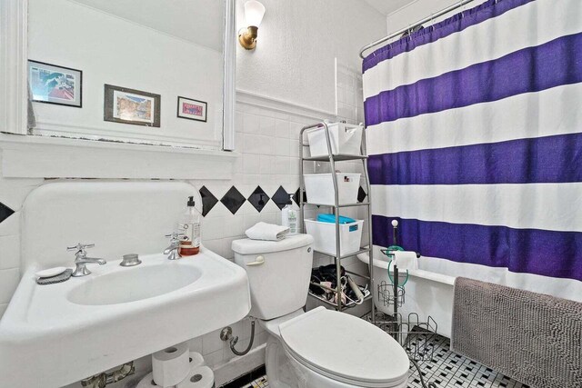 3316 W Wisconsin Ave, Milwaukee, WI 53208 - bathroom featuring toilet, tile walls, a shower with curtain, and a sink