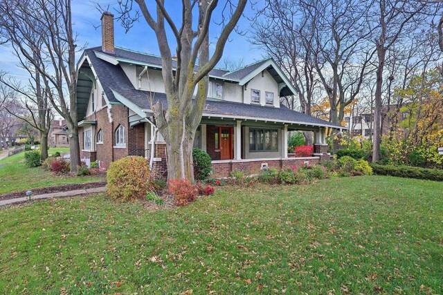 3316 W Wisconsin Ave, Milwaukee, WI 53208 - view of front of home featuring a shingled roof, brick siding, a chimney, and a front lawn