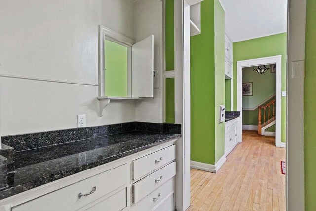 3316 W Wisconsin Ave, Milwaukee, WI 53208 - kitchen with white cabinets, light wood-style flooring, baseboards, and dark stone counters