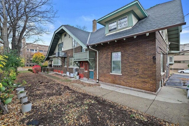 3316 W Wisconsin Ave, Milwaukee, WI 53208 - back of property with a chimney, a shingled roof, and brick siding