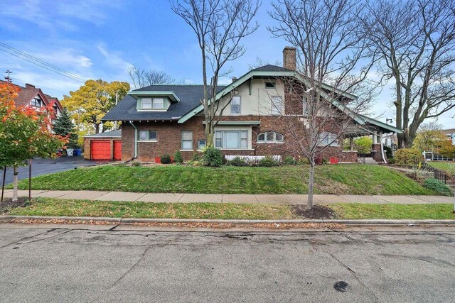 3316 W Wisconsin Ave, Milwaukee, WI 53208 - view of front of home with a chimney, an attached garage, aphalt driveway, a front yard, and brick siding