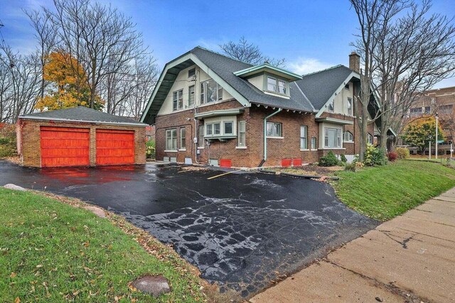 3316 W Wisconsin Ave, Milwaukee, WI 53208 - view of front of home with an outbuilding, roof with shingles, a front lawn, brick siding, and a chimney