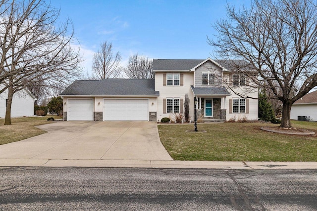 traditional home featuring concrete driveway, a garage, stone siding, and a front yard
