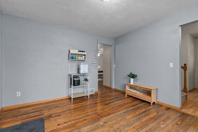 empty room with visible vents, baseboards, and hardwood / wood-style floors