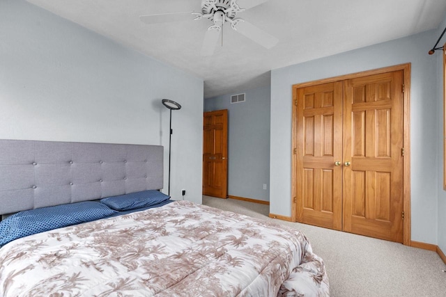 carpeted bedroom with visible vents, baseboards, and a ceiling fan